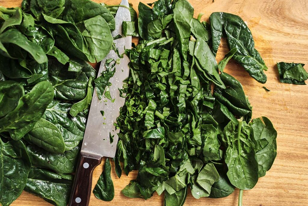 A bowl of frozen spinach transitioning to room temperature, ready for dip preparation