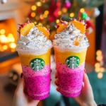 A tall glass of homemade Dragonfruit Refresher with vibrant pink color, garnished with fresh mint and dragonfruit slices, served over ice in a clear glass with a straw.